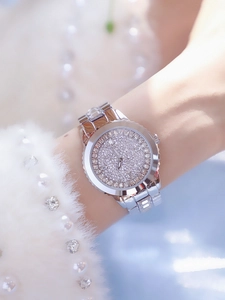 Close-up of luxury silver women's watch with full crystal pavé dial on wrist