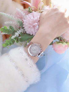 Close-up of a silver luxury women watch featuring a full pavé dial and crystal bezel