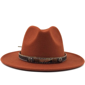 Rust red wool felt fedora with a flat wide brim and vintage bronze feather pendant detail