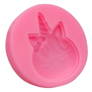 Dettaglio macro di uno stampo in silicone rosa con trame di testa di unicorno per dolci