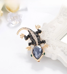 Detailed macro of a lizard brooch with enamel scales and sparkling blue gemstone