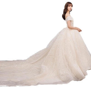 Elegant off-shoulder wedding dress with long train and glittering sequin starlight patterns