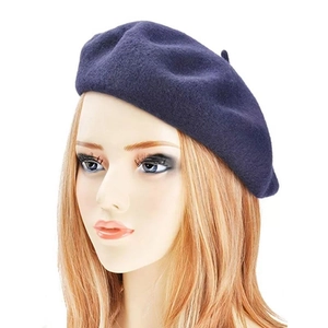 Detailed side view of a navy blue cashmere-feel beret shown on a model head