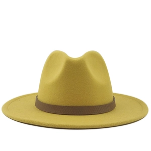 Gele wollen fedora hoed met een bruine lederen band op een heldere witte achtergrond