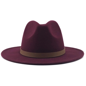 Detail van een wijnrode wollen fedora hoed met brede rand en bruine leren sierband