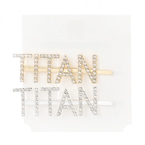 Close-up of TITAN letter hair clips with rhinestones in gold and silver finish