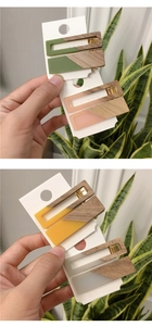 Detailed close-up of colorful matte acrylic and wood triangle hair clips on a card