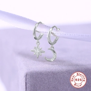 Detailed macro shot of S925 sterling silver star and moon earrings with cubic zirconia stones