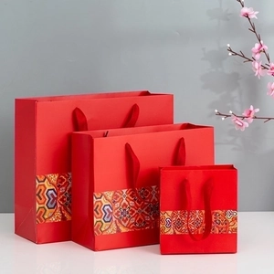 Three sizes of red Chinese style gift bags with floral patterns and rope handles