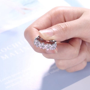 Close-up of elegant silver open ring with pink enamel flower on finger for women