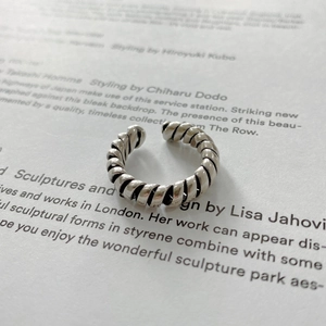 Close-up of a 925 sterling silver twisted rope ring on a minimalist white background