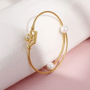 Elegant gold wire-wrapped bracelet featuring a rhinestone crown and white pearls