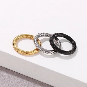 Three-piece ring set in gold, silver, and black with rhombic grid textured patterns