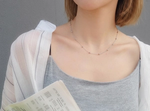 Minimalist silver mirror bead chain necklace in stainless steel worn by a model