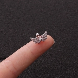 Silver angel wing stud earring with clear zircons and screw ball back on fingertip