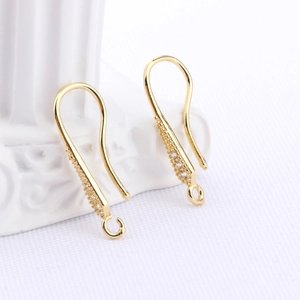 Macro shot of gold-plated DIY earring hooks with white zircon inlay and hanging loops