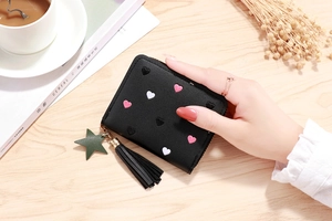 Close-up of black PU leather wallet with heart embroidery, star charm, and tassel detail