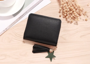 Close-up of black litchi grain faux leather wallet with star pendant and tassel zipper