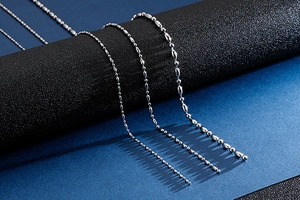 Vue détaillée de trois chaînes à billes en acier inoxydable sur un support noir