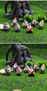 Detailed macro shot of 7 miniature resin garden gnomes set in a mossy forest micro-landscape