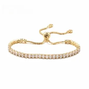 Adjustable bolo bracelet in gold-plated copper with clear zircon stones on white background