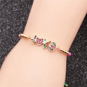 Adjustable woven bracelet with gold LOVE lettering and colorful zircon winged heart charm