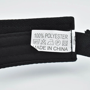 Detail shot of the 100% polyester fabric care label on a black sun visor hat