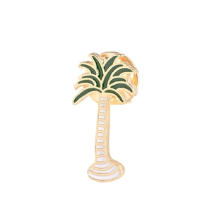 Gros plan sur la broche palmier tropical en métal doré et finition émail vert