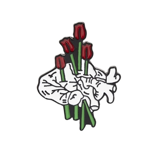 Creative anatomical heart enamel pin featuring red tulips on a white background
