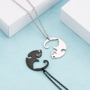 Détail de pendentifs chats yin yang emboîtables en noir et argent sur chaîne