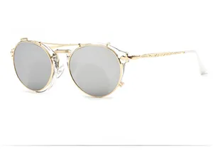 Detail view of round silver mirrored sunglasses with intricate gold temple engravings