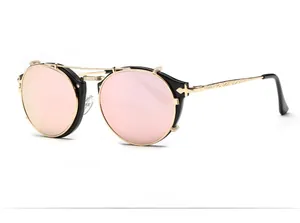 Macro view of vintage round sunglasses with gold floral engraved metal temples and pink lenses