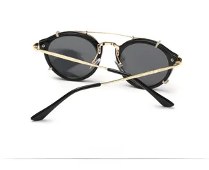 Detail view of round metal sunglasses with textured temples and gold-toned hinges