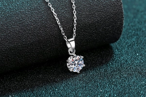 Macro shot of 1 carat moissanite pendant featuring classic six-prong setting on silver chain