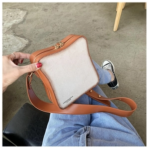 Dettaglio della borsa a tracolla creativa a forma di toast con peluche e finiture in pelle