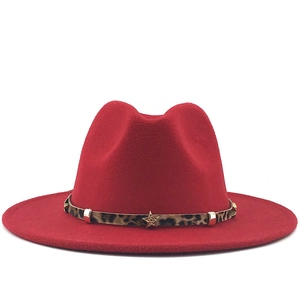 Red wool fedora hat with leopard print band and gold star studs on a white background