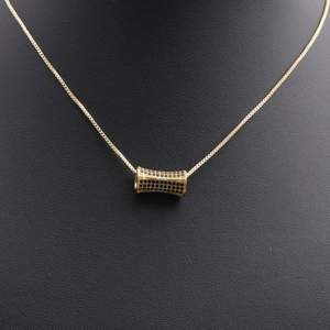 Macro shot of gold pendant with black micro-zirconia on a slender golden necklace