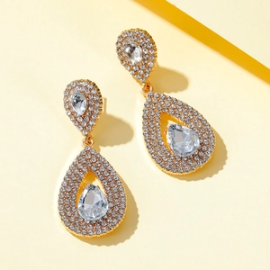 Close-up of luxury drop earrings with sparkling pear-cut crystals and gold-plated finish