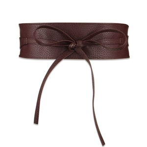 Detail of burgundy textured leather wide corset belt with a stylish bow tie closure