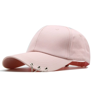 Détail de la casquette rose avec trois anneaux métalliques argentés sur la visière style