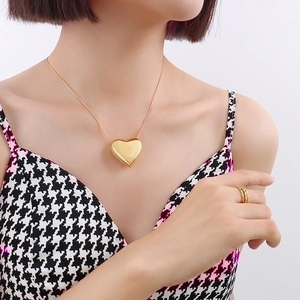 Elegant 18k gold heart pendant necklace and multi-layer rings on a fashion model