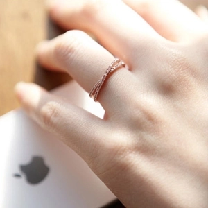 Crossed 18k rose gold ring with pavé micro-diamonds shown worn on female finger
