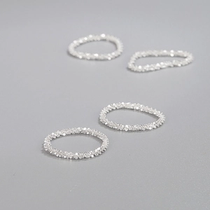 Minimalist 925 sterling silver rings with a sparkling textured finish on grey background
