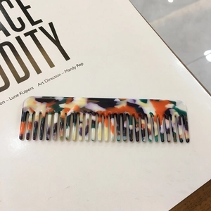 Colorful tortoiseshell acetate hair comb with marble pattern texture and artistic design