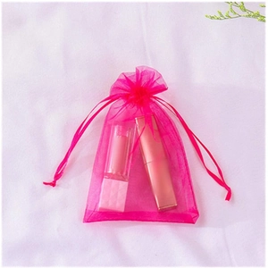 Pink drawstring organza gift bag showing storage capacity with cosmetics inside