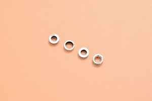 Macro detail of four S925 sterling silver spacer beads with vintage engraved patterns