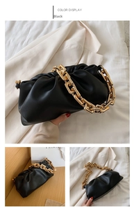 Detail of black cloud-shaped pouch bag featuring a thick chunky gold metal chain strap