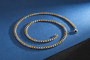 Close-up of polished two-tone gold and silver Cuban chain necklace with lobster clasp