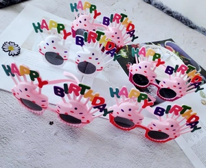 Close-up of colorful Happy Birthday cake party glasses in pink, red, and white frames