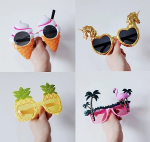 Detail view of four novelty party sunglasses including pineapple and flamingo styles